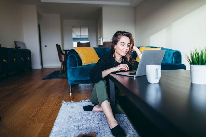 Smiling woman sits in her home after applying for a Marsden First Homes mortgage product.