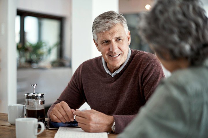 Smiling man enjoys a conversation with his wife after applying for an Retirement Interest Only mortgage with the Marsden.