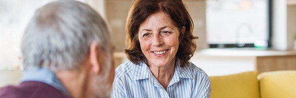 Smiling man enjoys a conversation with his wife after applying for an Retirement Interest Only mortgage with the Marsden.