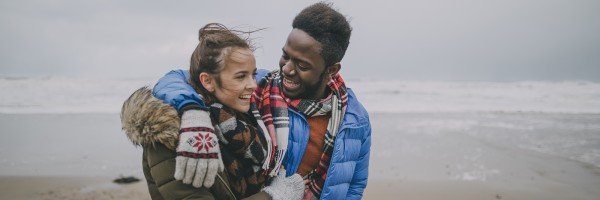 Young couple happy and smiling while walking on a beach