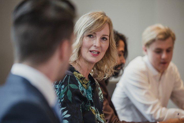 Woman in a meeting with her colleagues to discuss mortgage products.