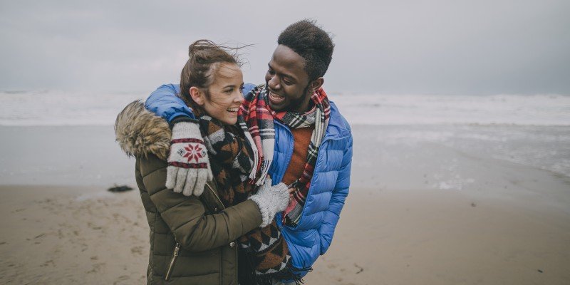 Young couple happy and smiling while walking on a beach