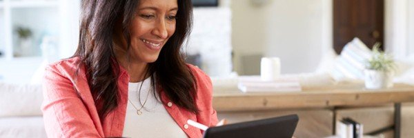 Smiling woman sits in her home after applying for a Marsden Furnished Holiday Let mortgage product.