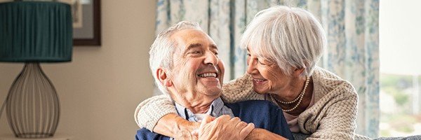 An old couple smiling and hugging in their home after receiving help with a Later Life mortgage from Marsden Intermediaries